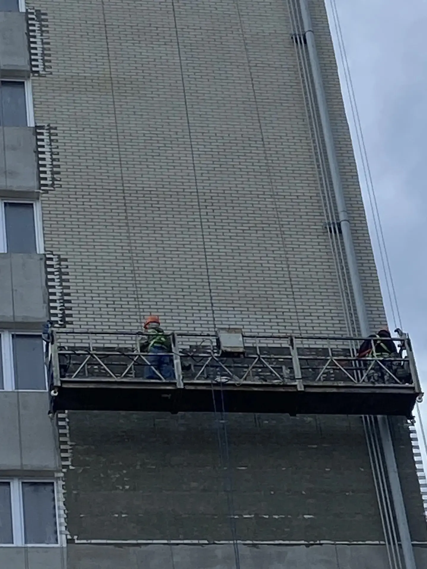 Высотный монтаж гибкого кирпича на фасаде многоэтажного дома