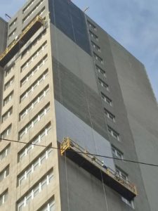Высотный монтаж гибкого кирпича на фасаде многоэтажного здания с подвесных платформ